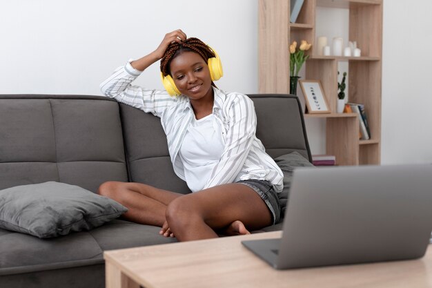 Frau mit mittlerer Aufnahme, die auf der Couch sitzt