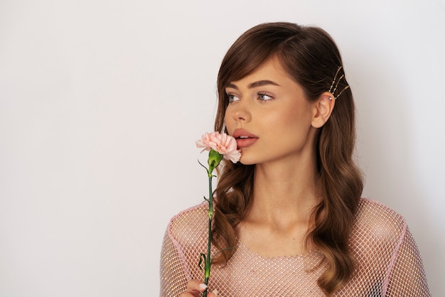 Kostenloses Foto frau mit mittlerer aufnahme, die blume hält holding