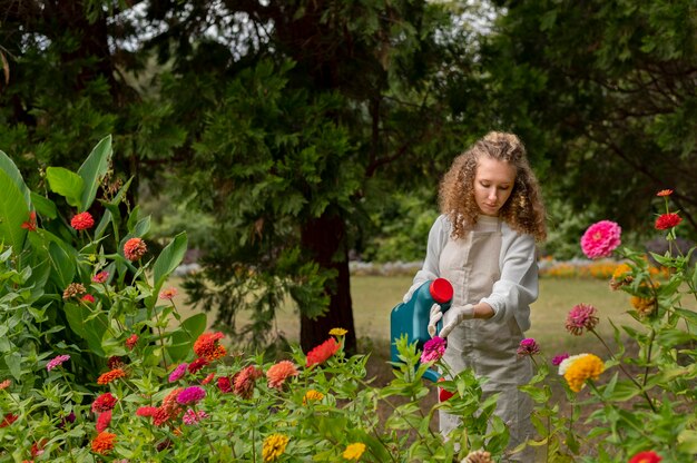 Frau mit mittlerer Aufnahme, die Blumen gießt