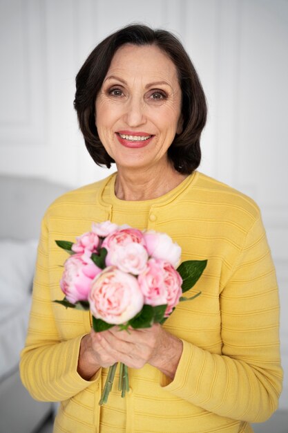 Frau mit mittlerer Aufnahme, die Blumen hält