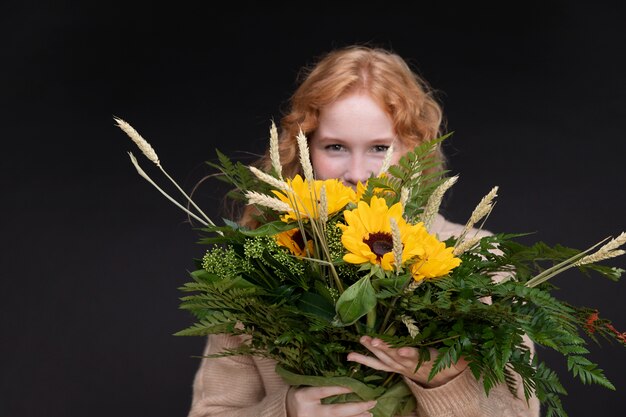 Frau mit mittlerer Aufnahme, die Blumenstrauß hält