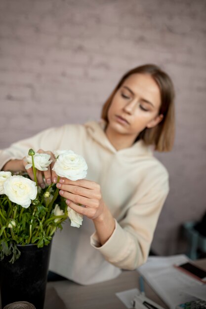 Frau mit mittlerer Aufnahme, die eine Blume hält