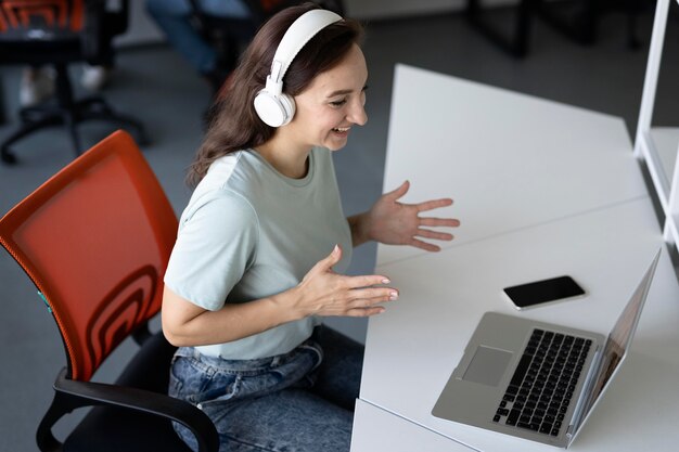 Frau mit mittlerer Aufnahme, die mit Laptop arbeitet