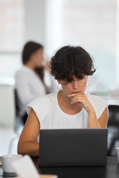 Frau mit mittlerer Aufnahme, die mit Laptop arbeitet