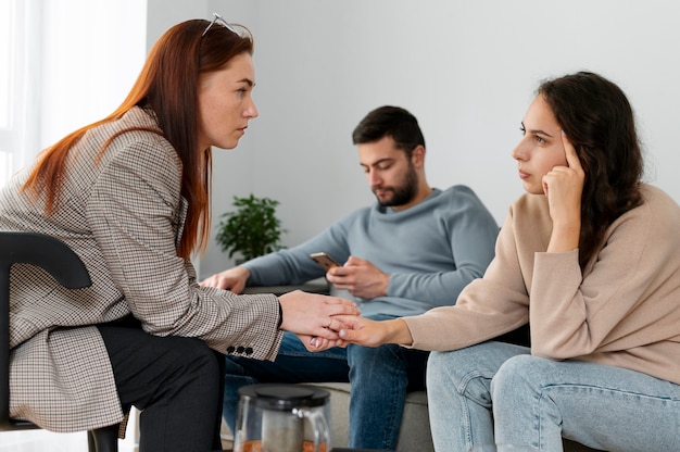 Frau mit mittlerer Aufnahme, die mit Therapeuten diskutiert