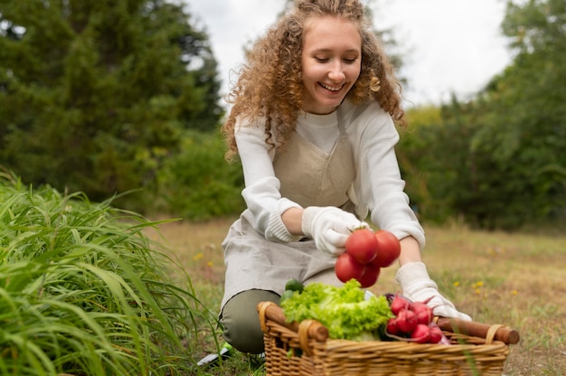 Frau mit mittlerer Aufnahme, die Tomaten hält