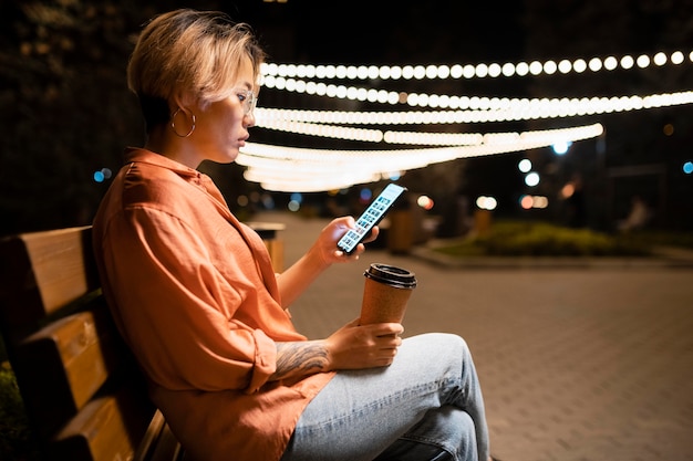 Kostenloses Foto frau mit mittlerer aufnahme sitzt mit telefon