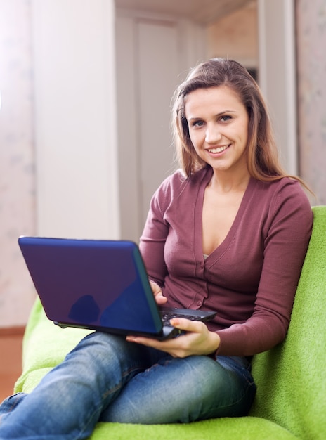 Frau mit Netbook im Haus