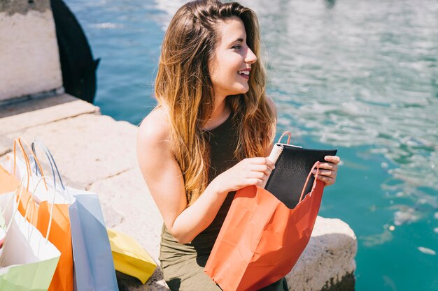 Frau mit neuer Handtasche am Meer