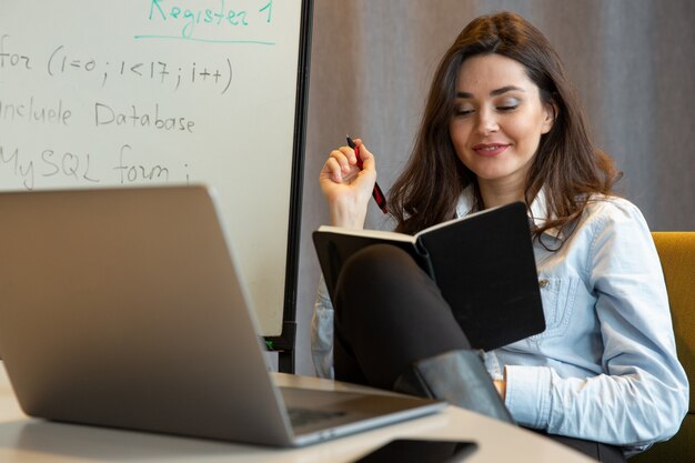 Frau mit Notizblock und Stift in ihren Händen