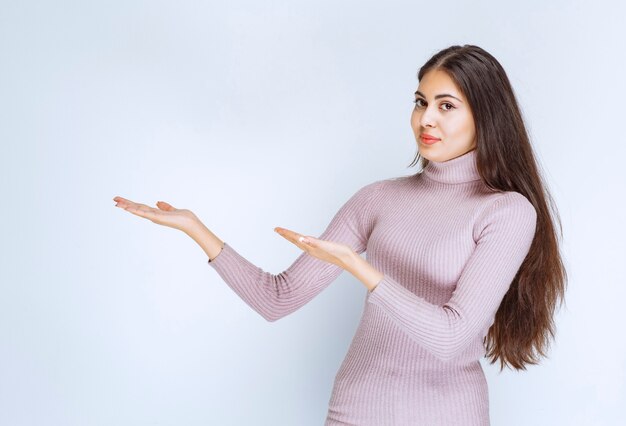 Frau mit offener Hand, um etwas zu präsentieren oder zu erklären.