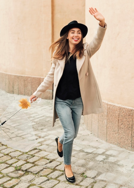 Frau mit Regenschirm, der ihren Arm angehoben hat