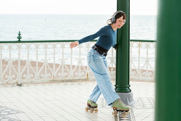 Frau mit Rollschuhen, die im Freien rollen und Musik hören