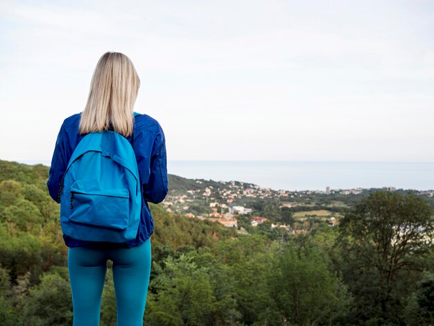 Frau mit Rucksack oben auf Berg