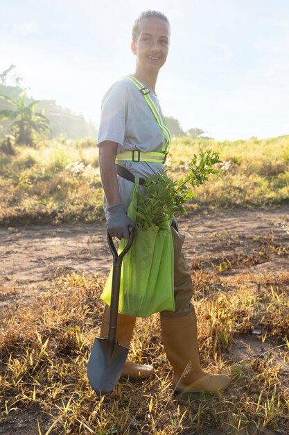 Frau mit Schaufel auf dem Land