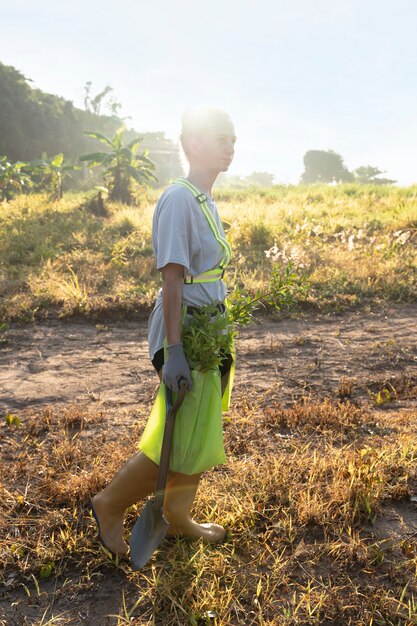 Frau mit Schaufel auf dem Land