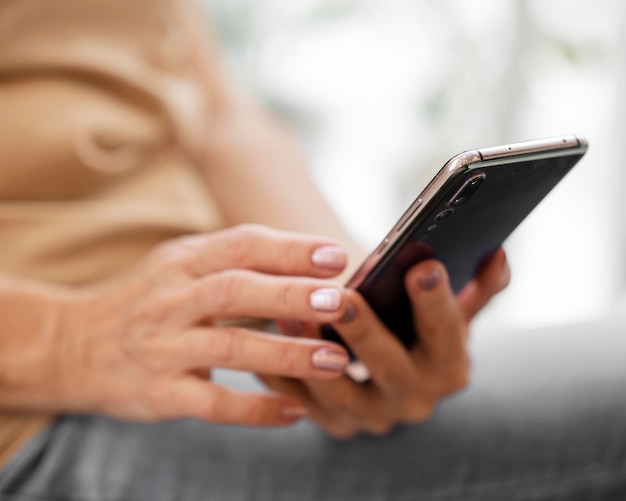 Kostenloses Foto frau mit smartphone drinnen