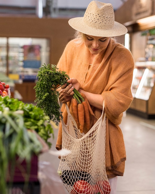 Kostenloses Foto frau mit sommerhut, die produkte kauft