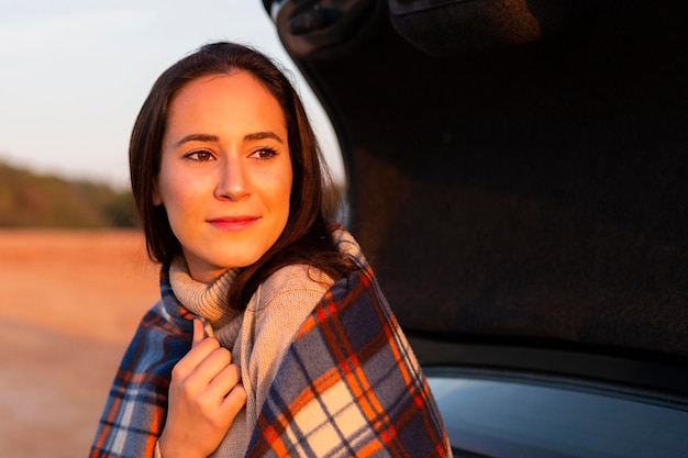 Frau mit Sonne, die auf ihrem Gesicht scheint, während draußen in der Natur