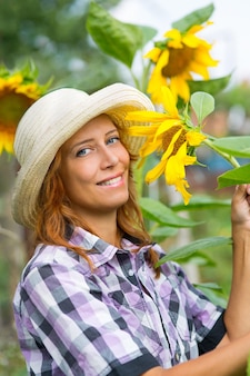 Frau mit sonnenblumen im garten