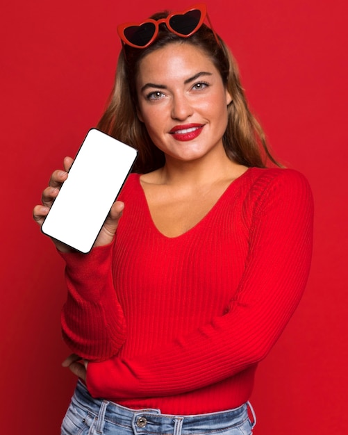 Frau mit Sonnenbrille hält Telefon