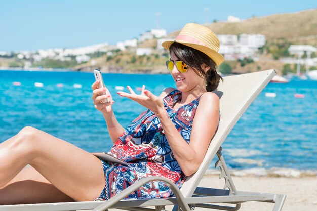 Frau mit Sonnenbrille und Hut eine mobile Suche