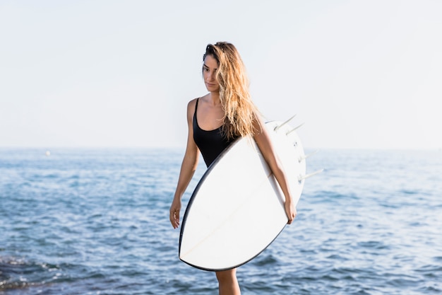 Kostenloses Foto frau mit surfbrett am strand