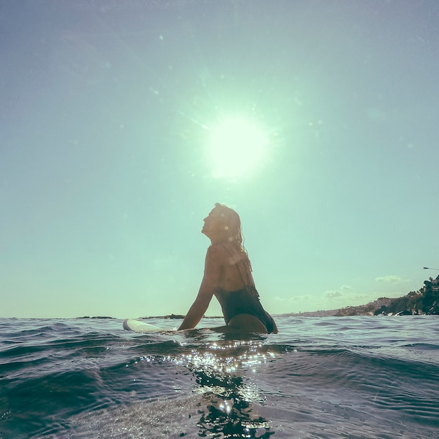 Frau mit Surfbrett im Wasser