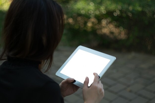 Frau mit Tablette im Garten