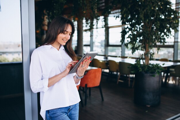 Frau mit Tablette in einem Café