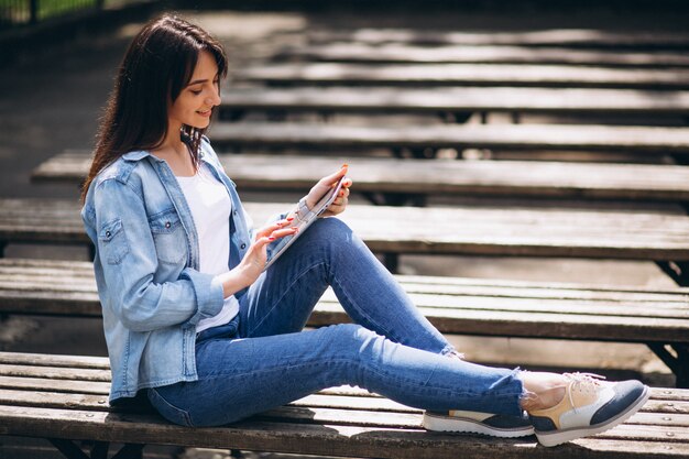 Frau mit Tablette in einem Park