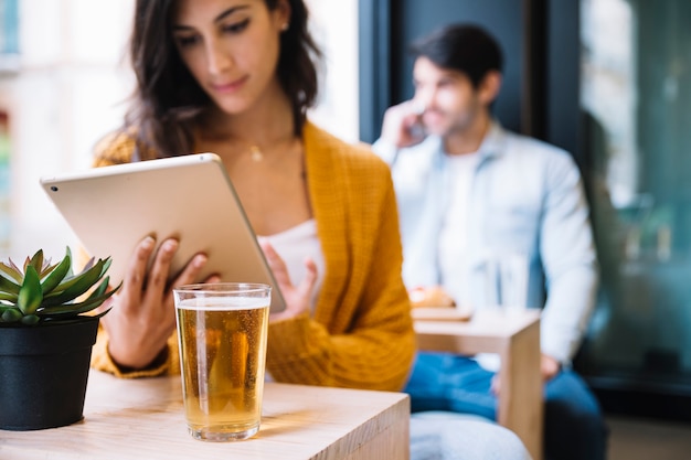 Kostenloses Foto frau mit tablette und getränk im café