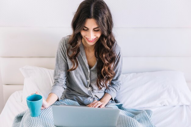 Frau mit Tasse und Laptop