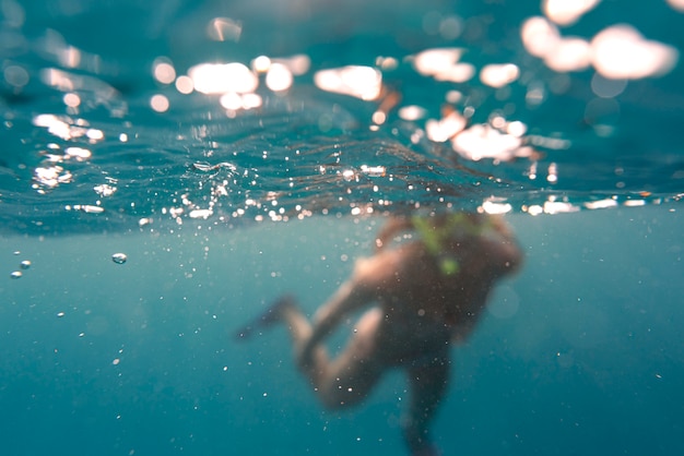 Frau mit Tauchausrüstung, die im Ozean schwimmt