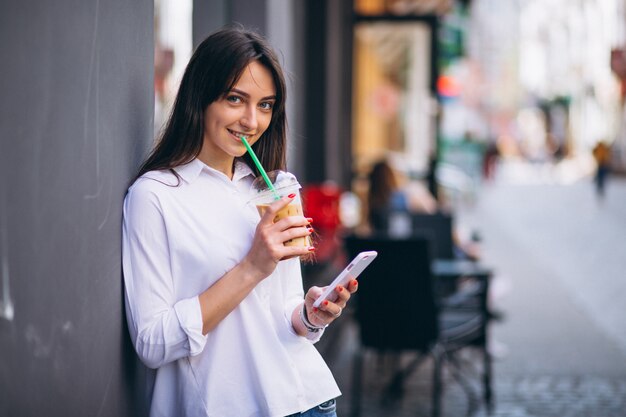 Frau mit Telefon und Kaffee