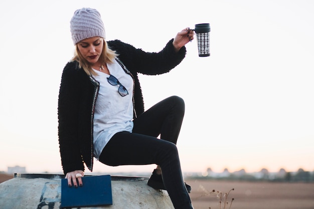 Frau mit Thermosflasche in der Natur