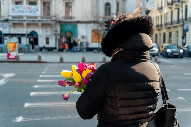 Kostenloses Foto frau mit tulpen auf einer straße in bukarest rumänien