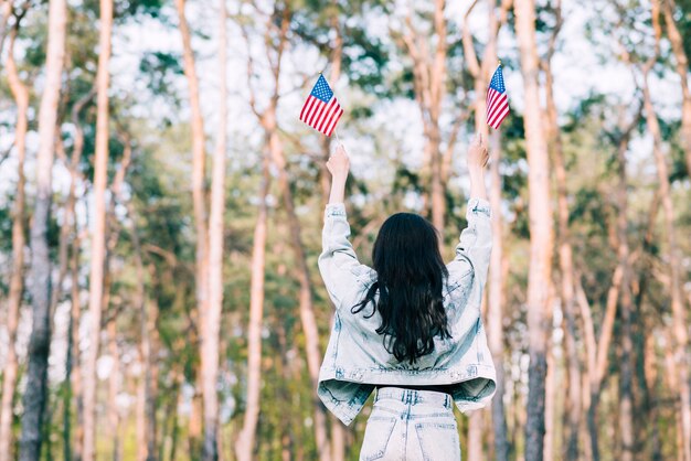 Frau mit USA-Flaggen in ausgestreckten Händen