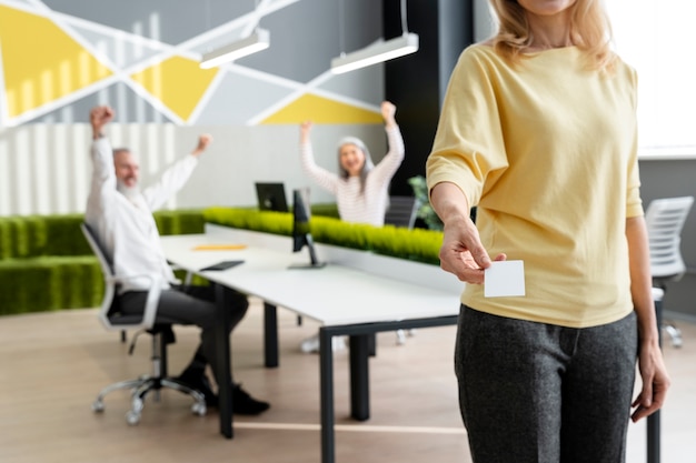 Kostenloses Foto frau mit visitenkarte im büro