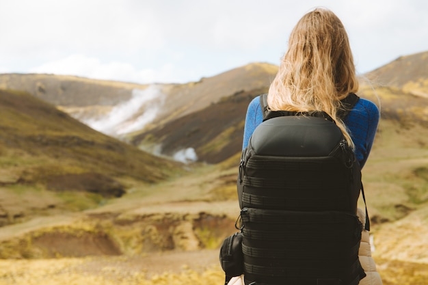 Kostenloses Foto frau mit wanderrucksack, der die schönen berge in island betrachtet