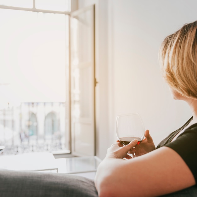 Kostenloses Foto frau mit wein auf der couch