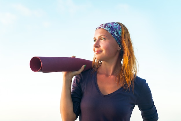 Frau mit Yogamatte