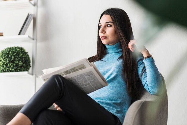 Frau mit Zeitung im Sessel