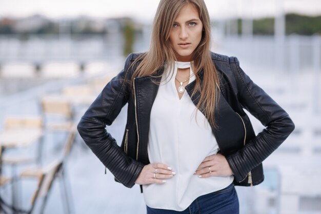 Frau posiert mit den Händen auf den Hüften in einem Restaurant auf einem Seehafen