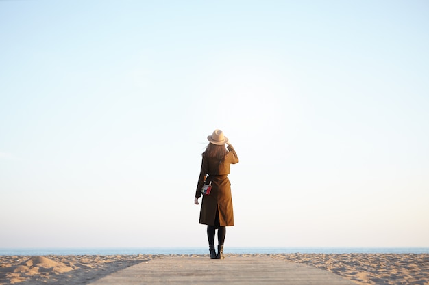 Frau Reisende genießen Blick auf ruhiges Meer im Herbst oder Frühling Outwear in die Ferne schauen.