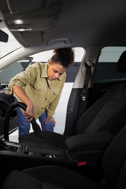 Kostenloses Foto frau saugt die autositze ab