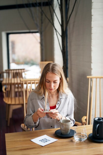 Frau scannt QR-Code im Restaurant