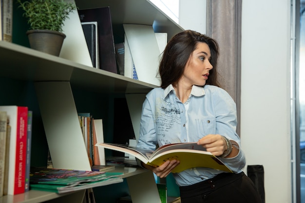 Kostenloses Foto frau schauen irgendwo beim lesen des buches