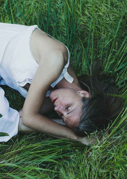 Frau schläft auf Gras