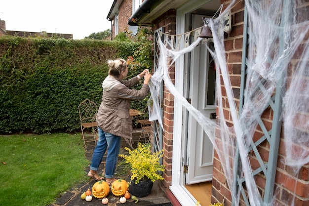 Frau schmückt ihr Haus für Halloween